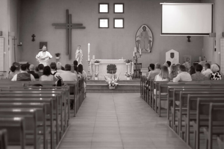 Cérémonie de baptême dans une église à Grasse, vue d’ensemble des invités et de l’autel.